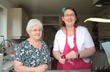 Wendy cooking with her Shared Lives carer, Grazelda. Both women are smiling at the camera.