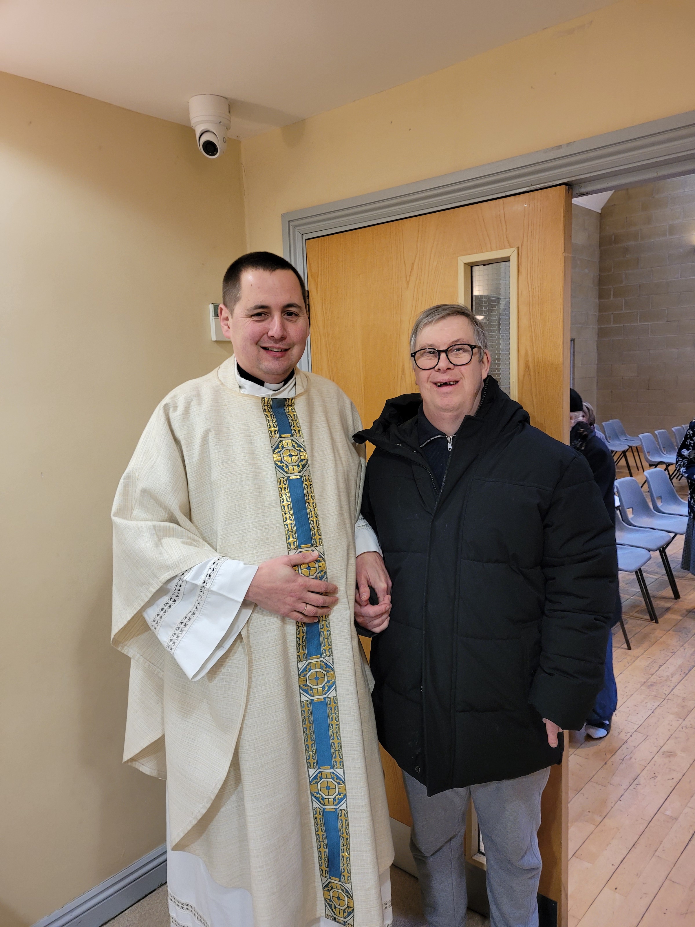 Stephen stood smiling with his priest.