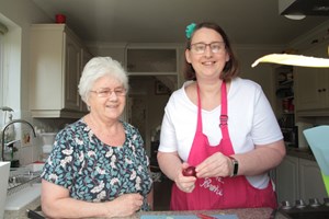 Wendy cooking with her Shared Lives carer, Grazelda. Both women are smiling at the camera.