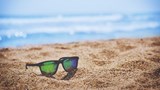 A pair of sunglasses on a sandy beach.