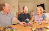 Martin and Liz supporting their son with learning disabilities play with his toy cars. 