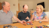 Martin and Liz supporting their son with learning disabilities play with his toy cars. 
