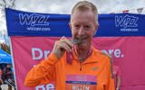 Wil finished the Cardiff half, stoook in front of a banner biting his medal.  