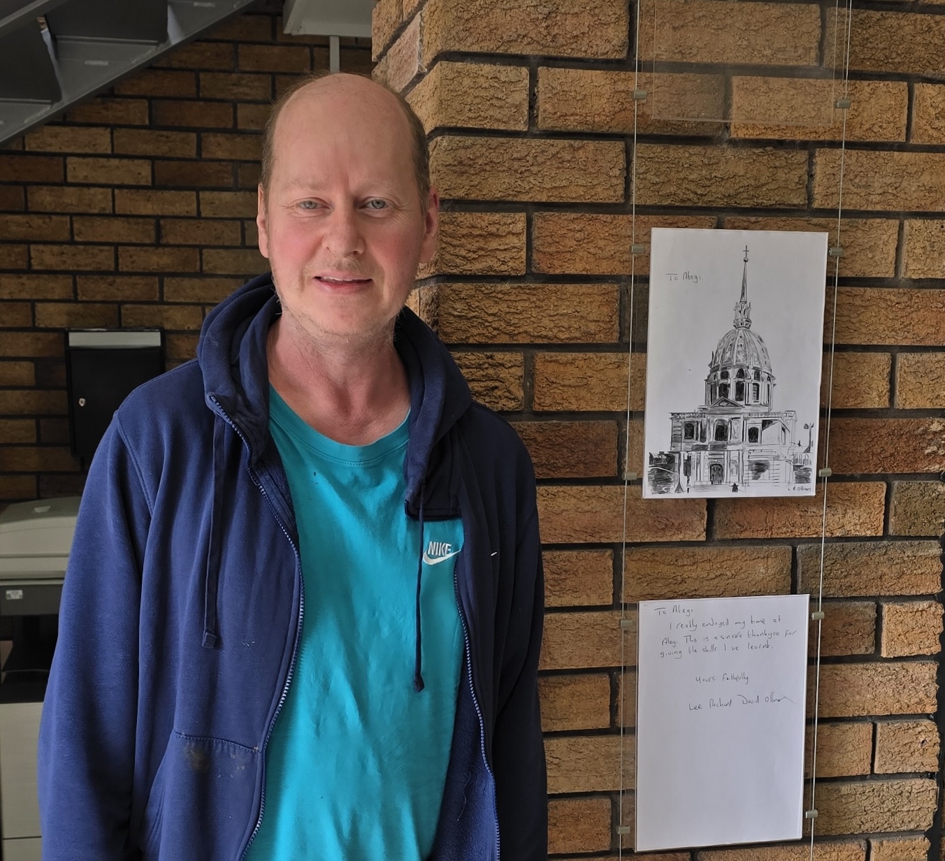 Lee standing next to one of his sketches that has been put up at Ategi headquarters.