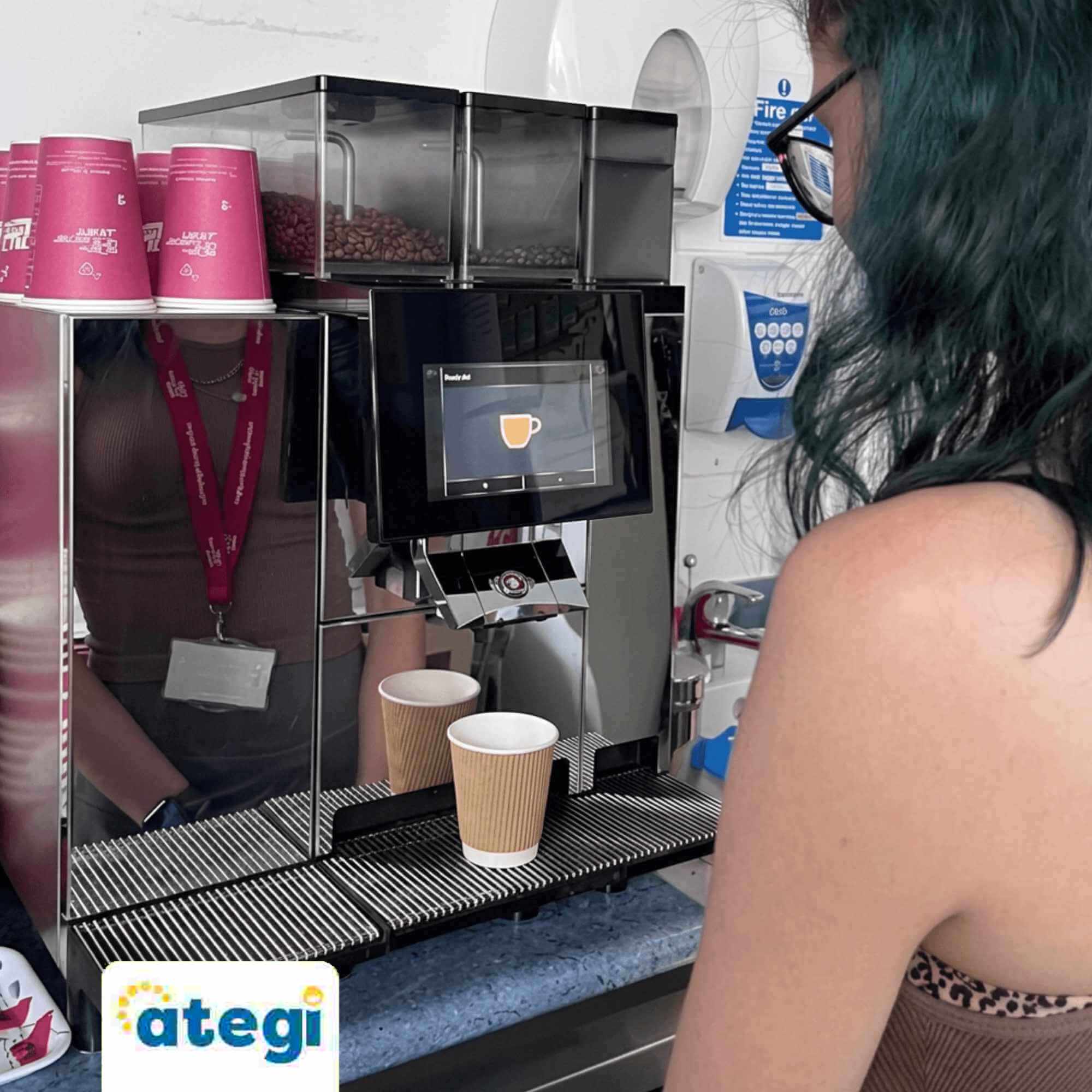 A photo of L making a hot drink using a coffee machine