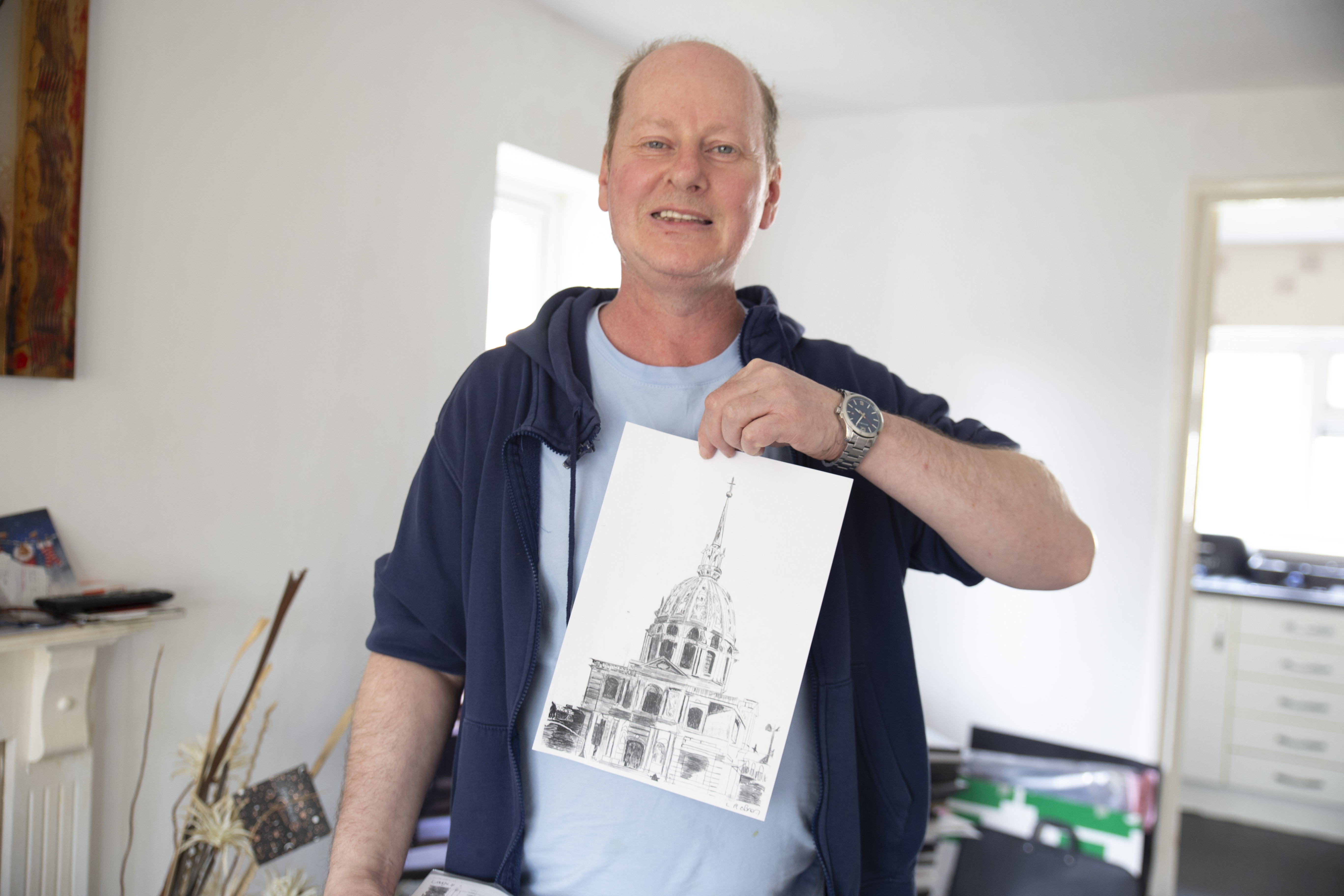 Lee holding up one of his sketches.