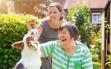 Two women playing with a dog. 