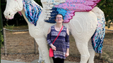 Kelsey stood with a really big lego unicorn. 