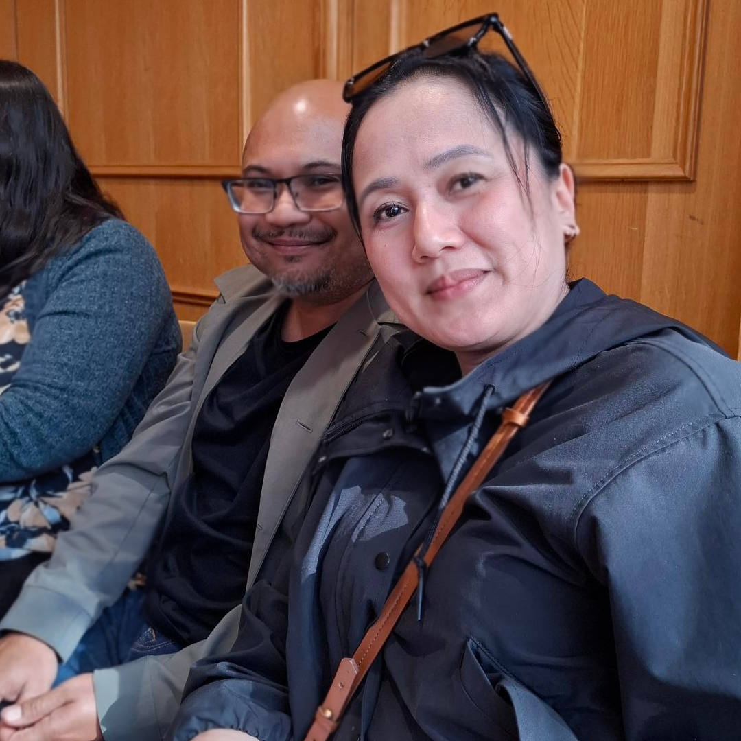 A seated couple looking to camera