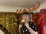 Josh, a young man, with a pair of reindeer antlers on his head.